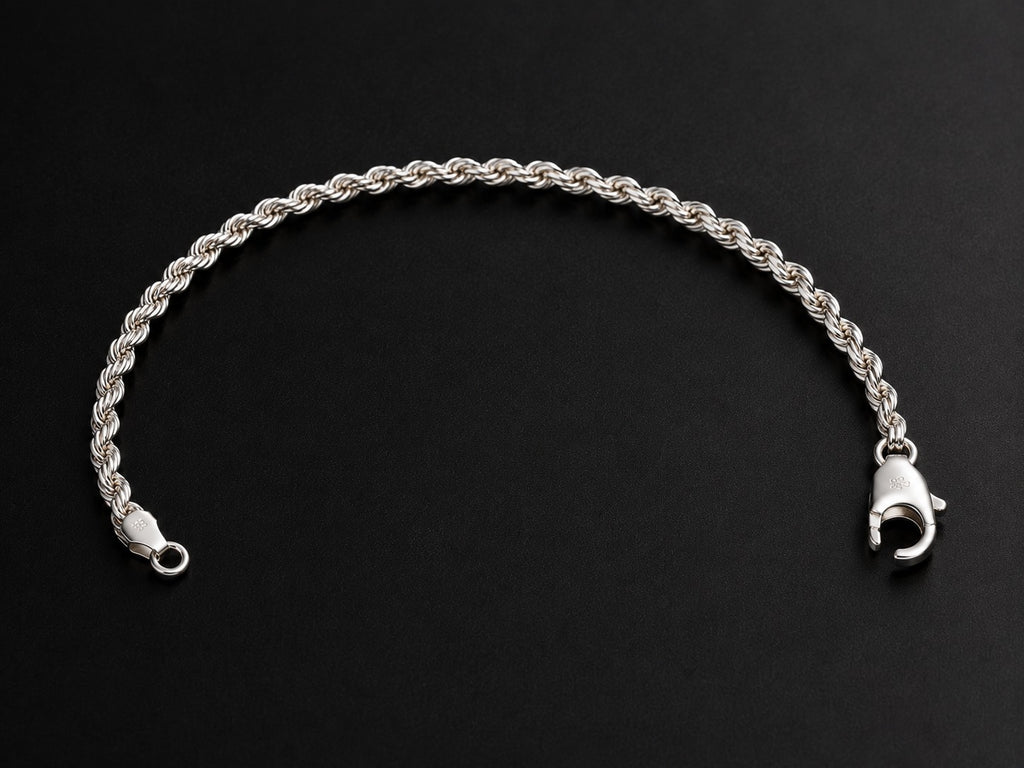 A silver rope chain bracelet with a lobster clasp, displayed on a dark black background.