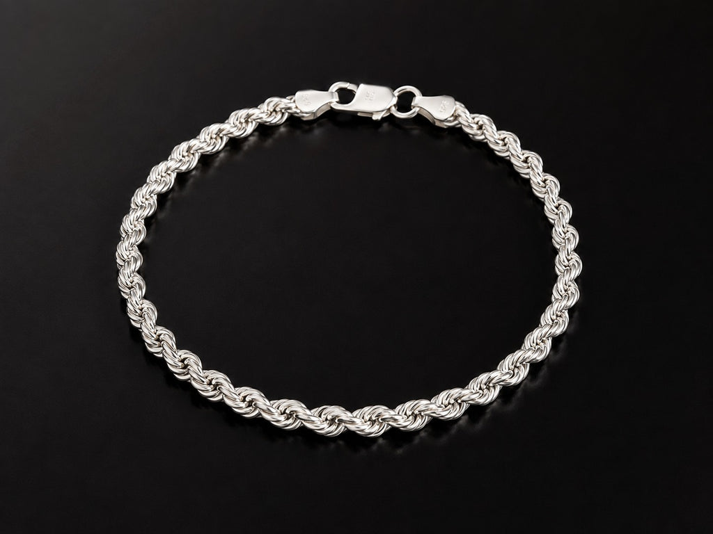 A silver-toned twisted rope chain bracelet with a lobster clasp, displayed on a reflective black surface.