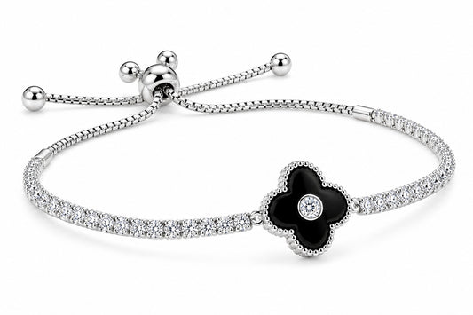 A silver-toned bracelet featuring a four-petal flower centerpiece with a black enamel center and a small clear stone, set on a pavé-set silver band with an adjustable sliding closure.