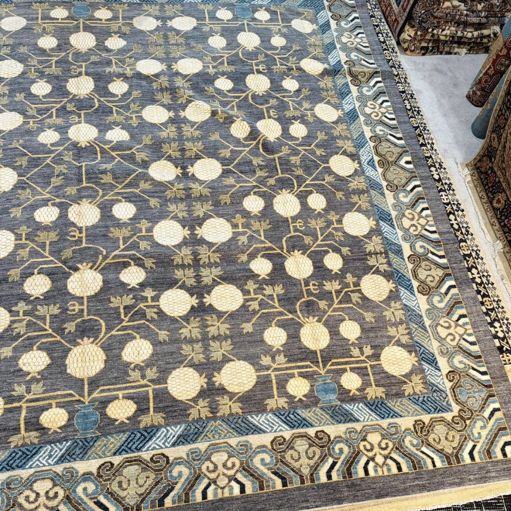 Close-up of the blue, cream, and beige geometric border on an Afghan hand-knotted wool rug.