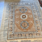 Detailed view of a traditional medallion motif on a tan and light blue Afghan Khotan-inspired wool rug.