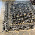 Black Afghan handknotted Khotan wool rug with cream geometric borders and a traditional Tree of Life pattern.