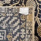 Detailed view of the black and cream Afghan Khotan rug featuring traditional geometric weaving and decorative motifs.