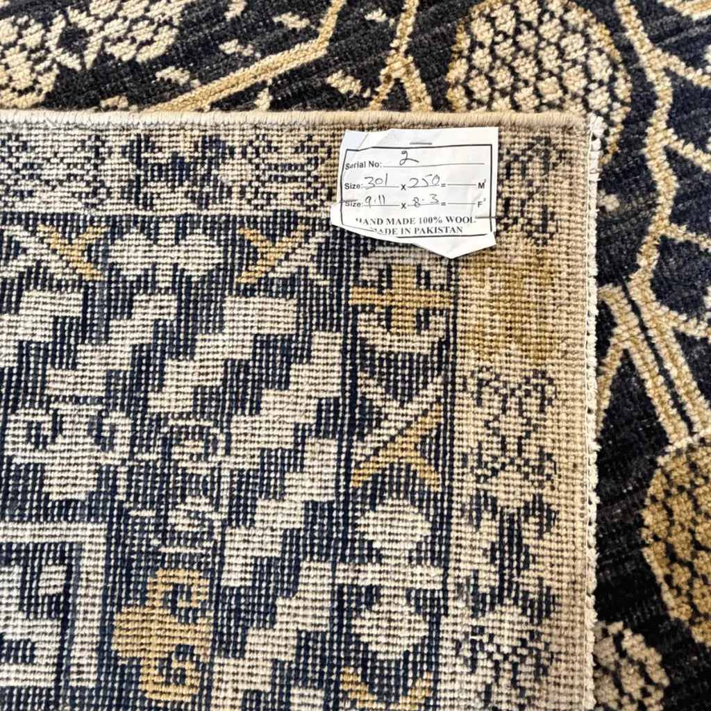 Detailed view of the black and cream Afghan Khotan rug featuring traditional geometric weaving and decorative motifs.