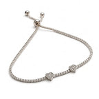 Dainty silver heart bracelet with two pavé heart charms and slim stone band, angled side view