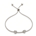 Silver double heart tennis bracelet with two pavé heart charms, cubic zirconia stones and adjustable slider closure
