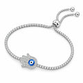 Sterling silver hamsa hand evil eye tennis bracelet with blue enamel eye, cubic zirconia stones and adjustable slider clasp