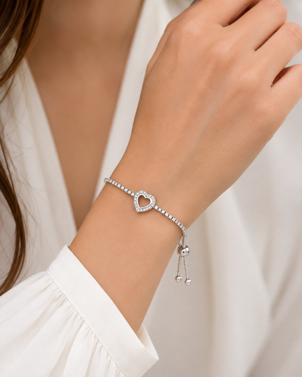 Close-up of sparkling heart charm on 925 sterling silver tennis bracelet with cubic zirconia stones.