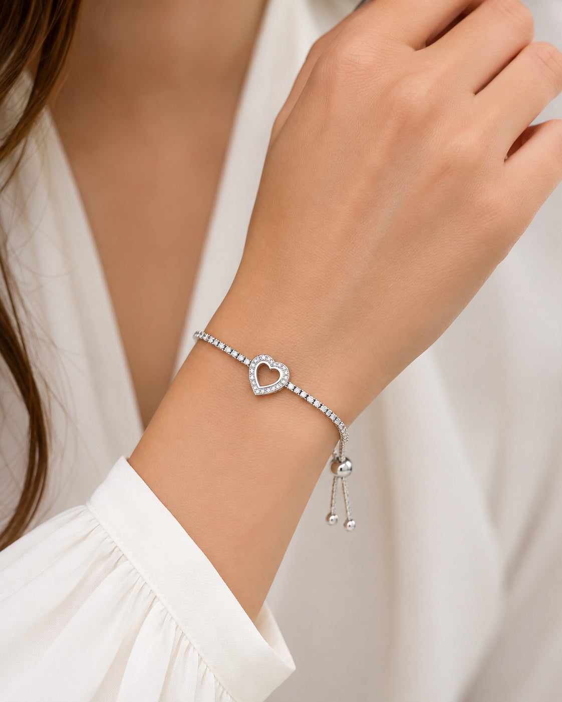 Close-up of sparkling heart charm on 925 sterling silver tennis bracelet with cubic zirconia stones.