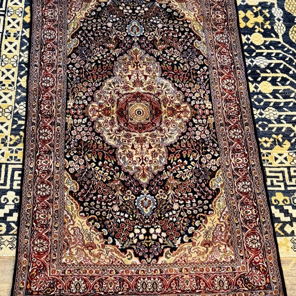 5.2 x 3.3 ft Kashmiri silk area rug with a traditional navy blue Persian-inspired medallion and multicolored floral design.