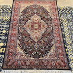 Cream-colored fringe and detailed woven edge of a traditional navy blue Kashmiri silk rug.