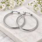 Side view of elegant sterling silver hoop earrings showcasing their slim design and polished surface.