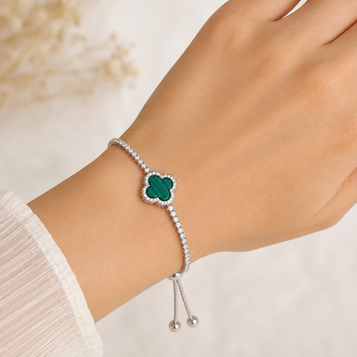 Elegant silver clover bracelet featuring a malachite four-leaf clover charm and sparkling zircon stones.