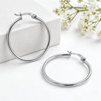 Minimalist silver hoop earrings displayed against a clean white background.