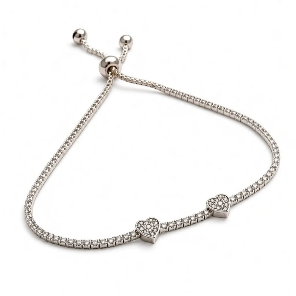 Silver pavé heart charm bracelet with thin tennis band and slider clasp, angled view