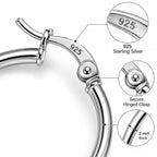 Close-up of silver hoop earrings featuring a secure hinged clasp and smooth polished finish.