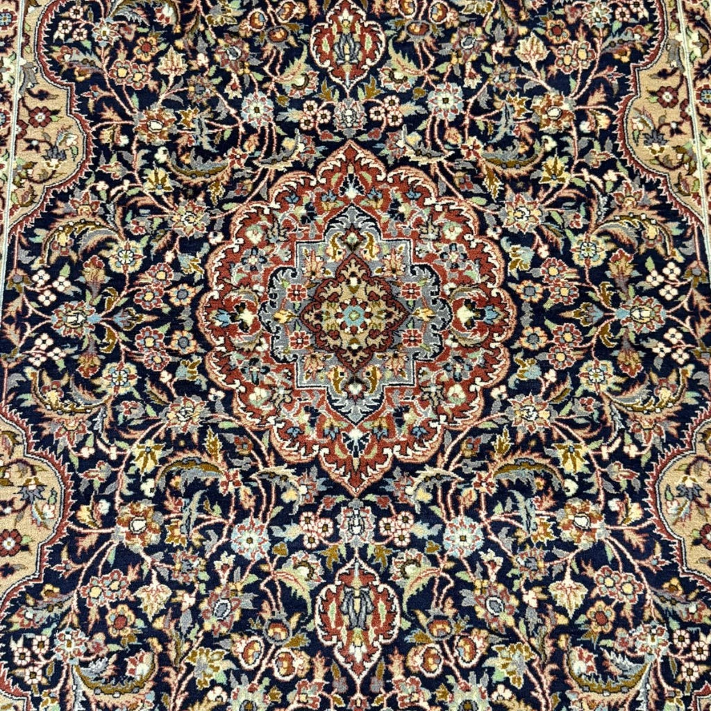 Close-up detail of intricate floral medallion pattern on vintage Tabriz-style Persian rug