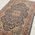 Vintage Tabriz-style Persian rug with navy blue floral medallion and rust red border
