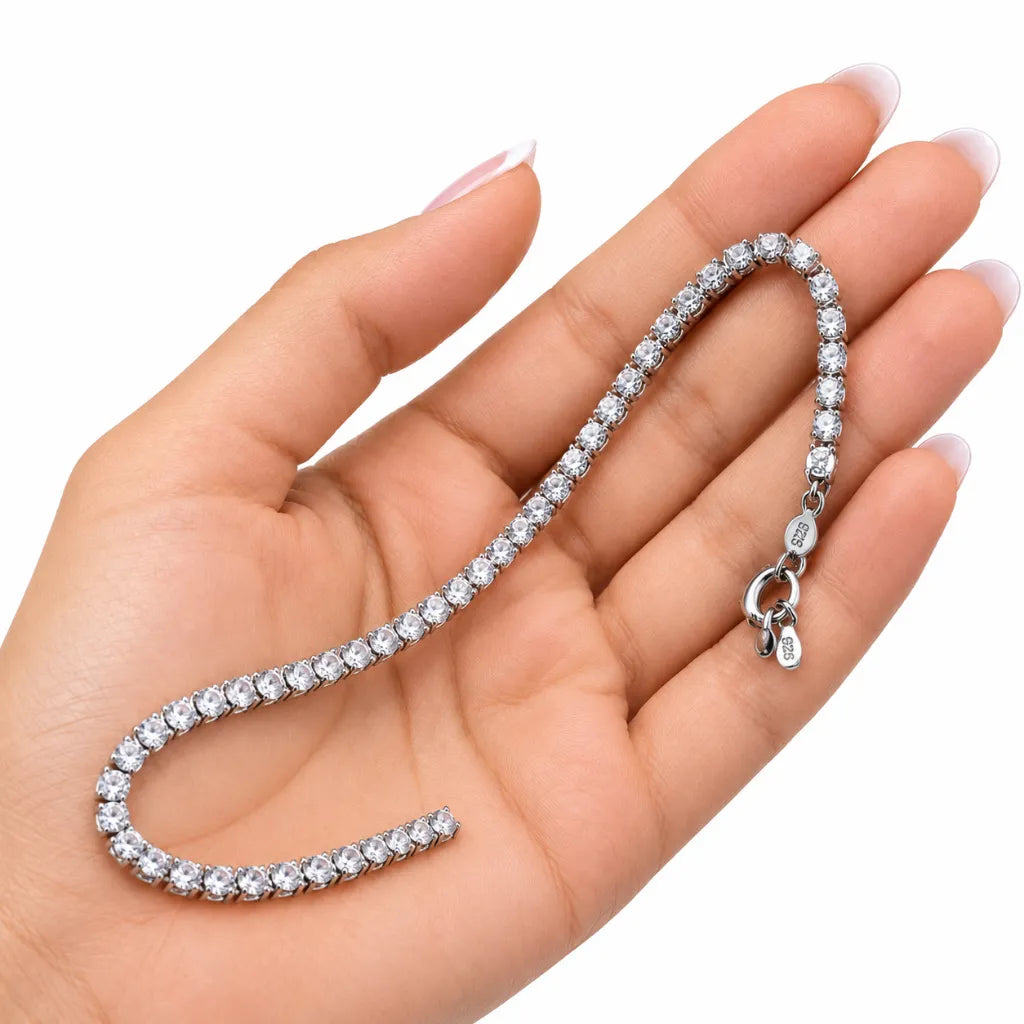 Woman holding silver cubic zirconia tennis bracelet in her palm showing size, clasp and 925 tag