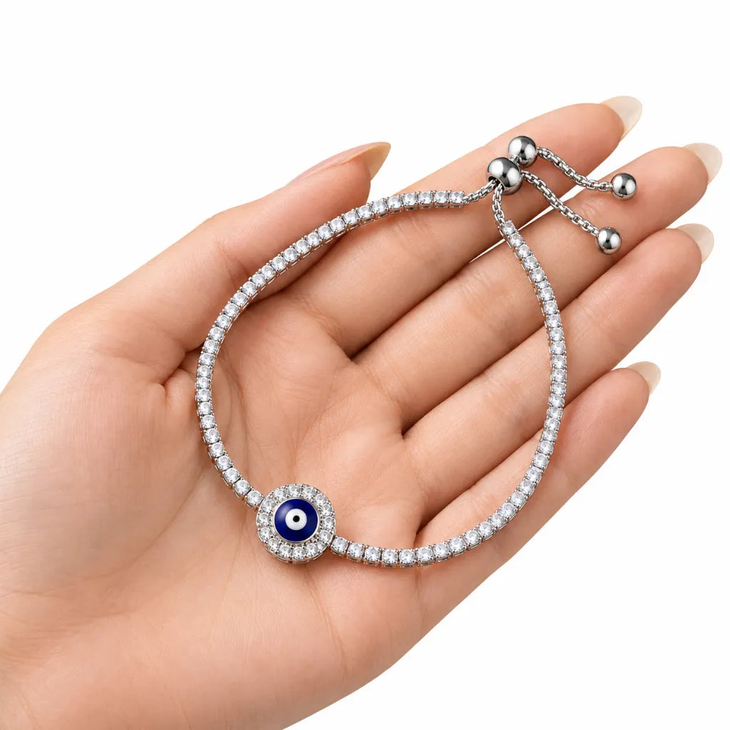 Woman holding 925 sterling silver evil eye tennis bracelet with sparkling cubic zirconia stones in her palm