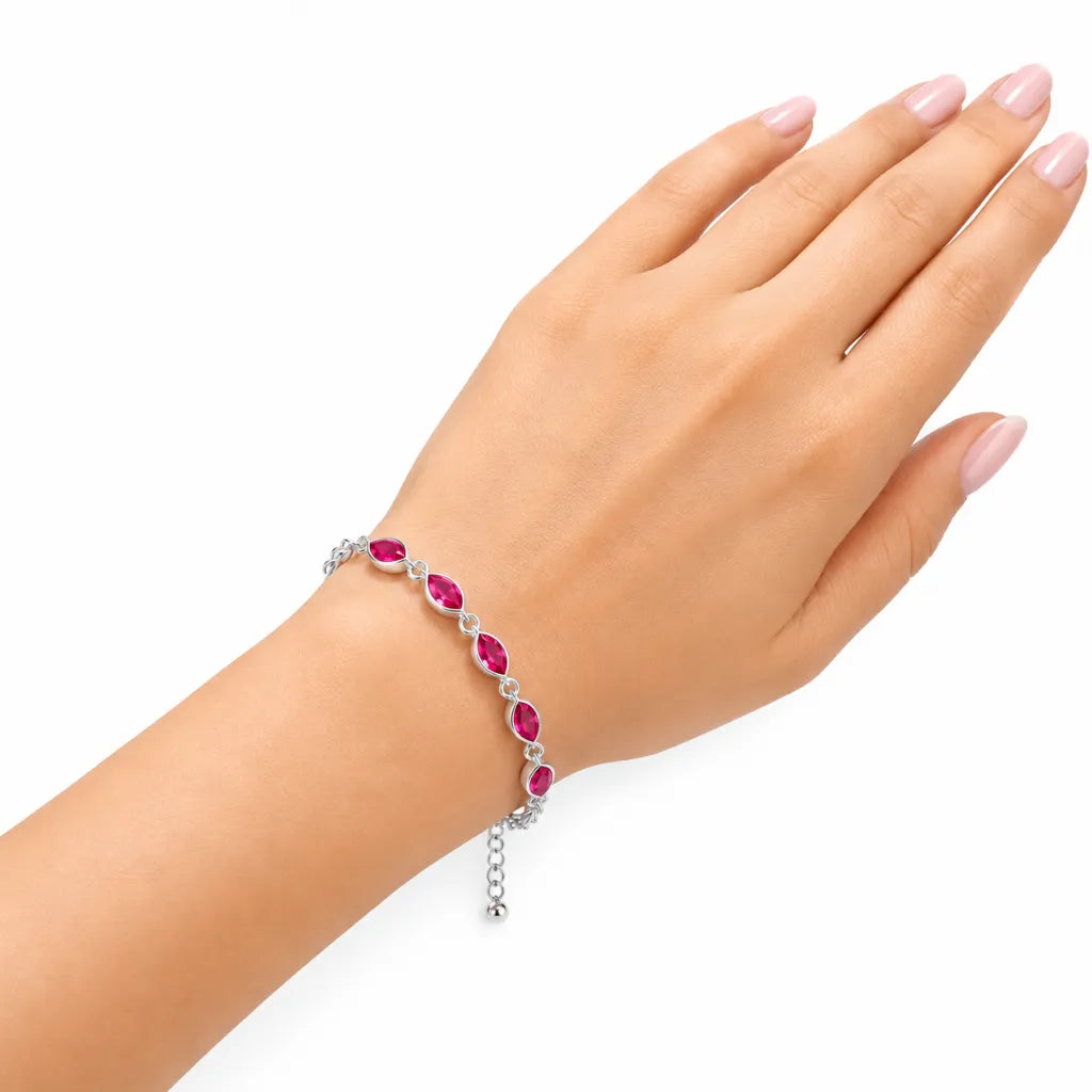 Woman wearing sterling silver ruby marquise bracelet with red gemstones and extender chain on wrist