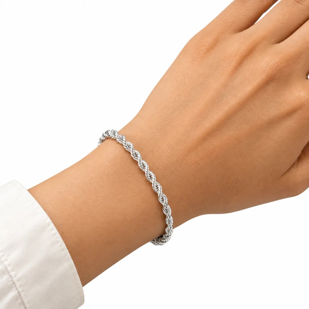 Woman wearing dainty sterling silver rope chain bracelet on wrist with white cuff shirt